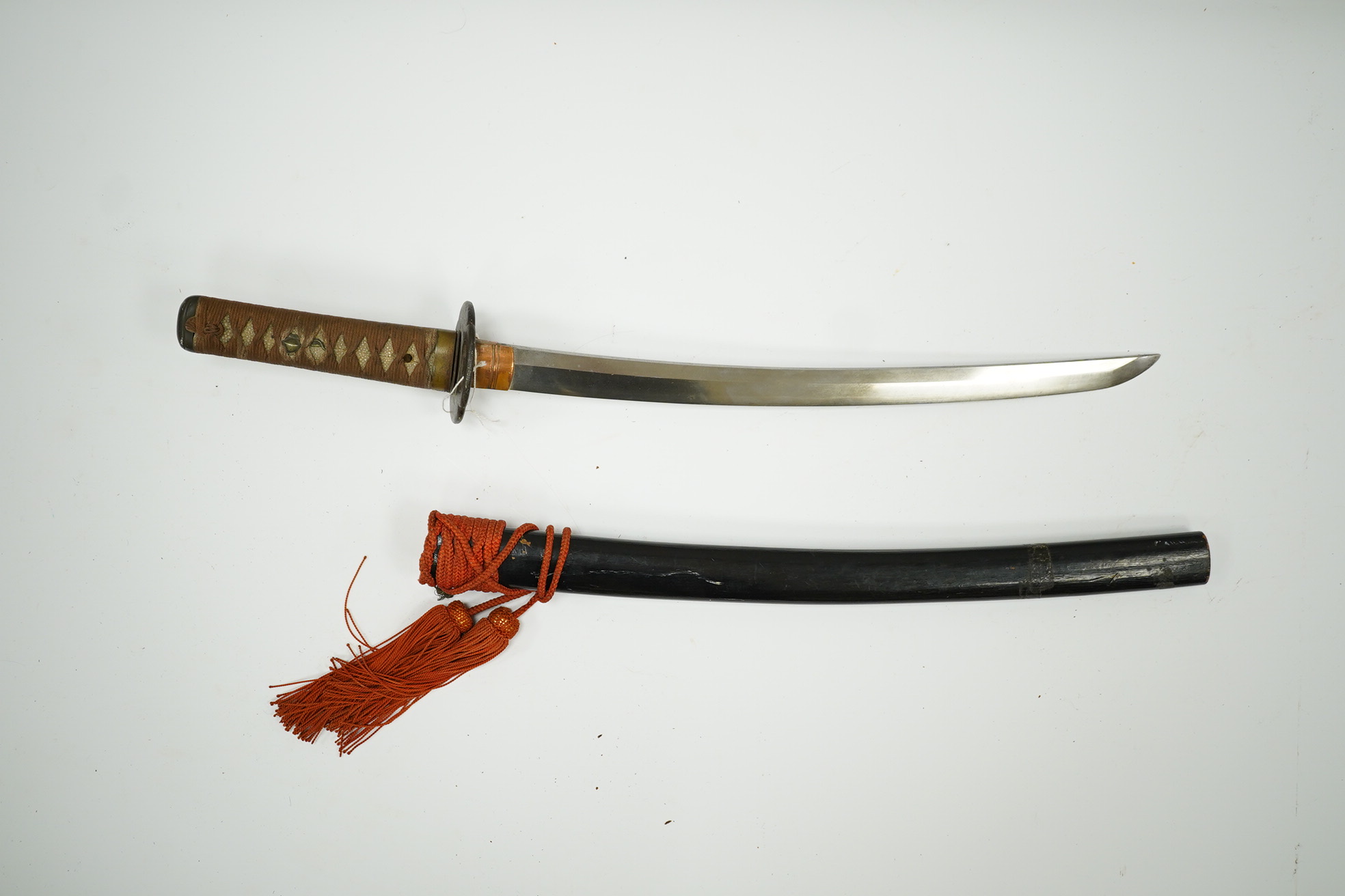 A 19th century Japanese sword wakizashi, blade 39.9cms, signed, iron Sukashi Tsuba of moko form, tape bound same tsuka with brass mounts, in its black lacquered saya. Condition - fair